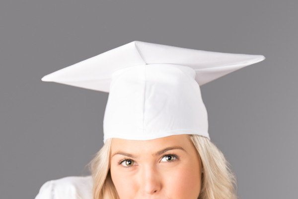 A girl wearing a white graduation cap and gown