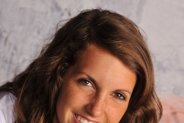 A girl smiling wearing a white shirt