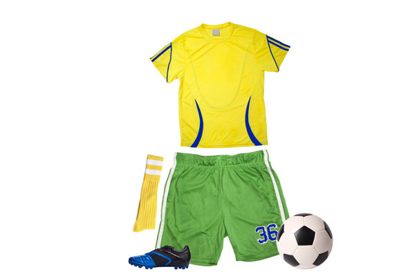 Yellow jersey, green athletic shorts, yellow socks, blue cleats, and soccer ball