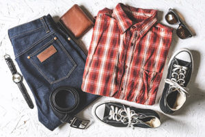 Red and white plaid shirt, blue jeans, black converse, black belt, brown wallet, and sunglasses