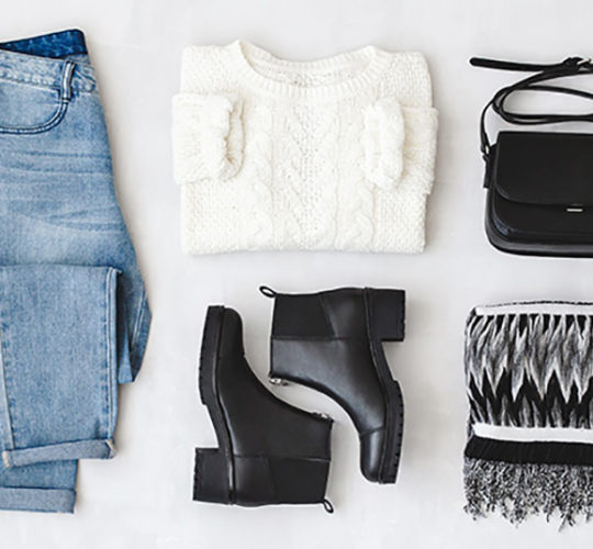 Jeans, white sweater, black boots, black purse, and black and white scarf