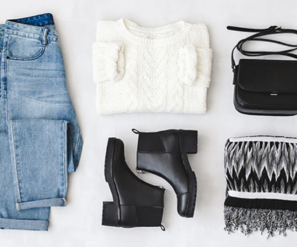 Jeans, white sweater, black boots, black purse, and black and white scarf