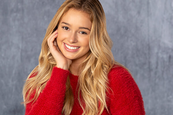 A girl smiling wearing a red sweater