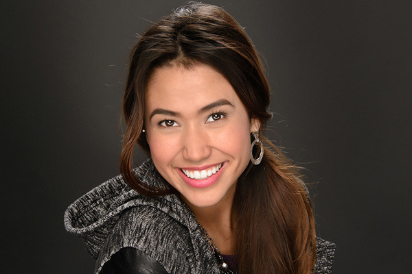 A girl smiling wearing a black hoodie jacket